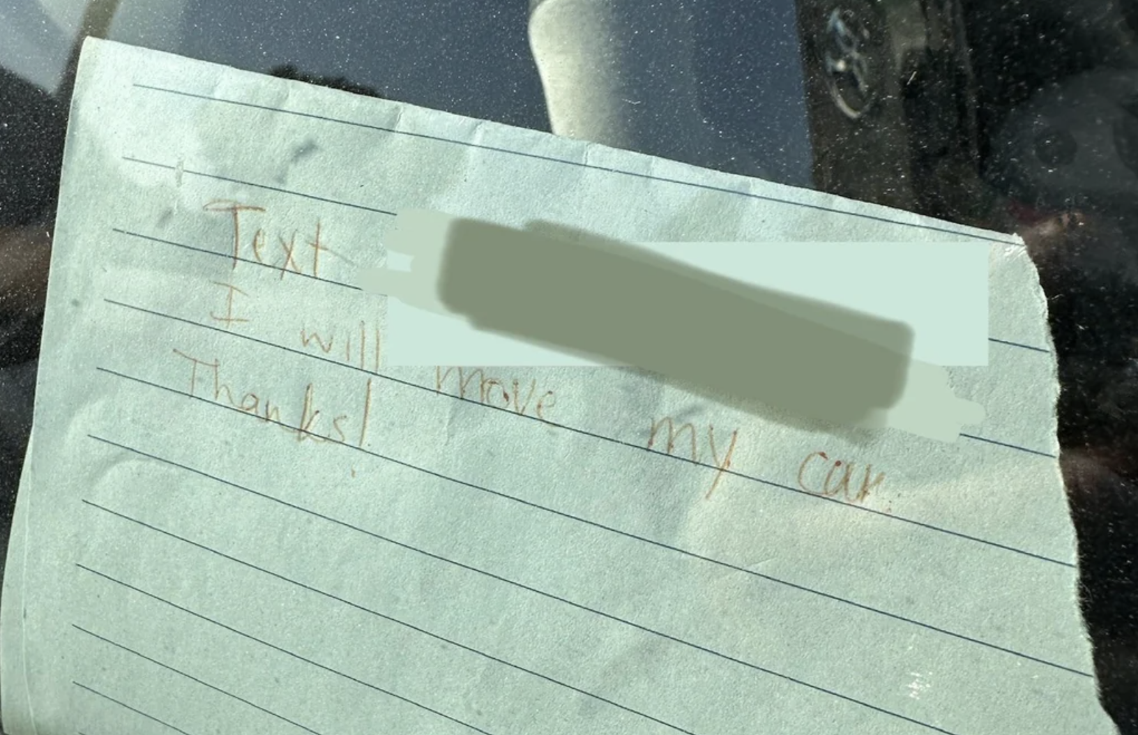 Note on a car window reads: "Text [number obscured], I will move my car. Thanks!"
