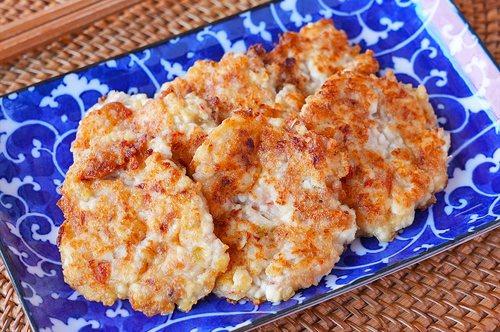 青い皿に盛り付けられた和風のつみれ料理。バックには小さな醤油皿と箸が見える。