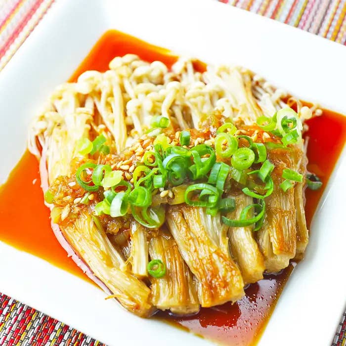 皿に盛られたえのきの料理。ネギが上に乗り、ソースがかかっています。