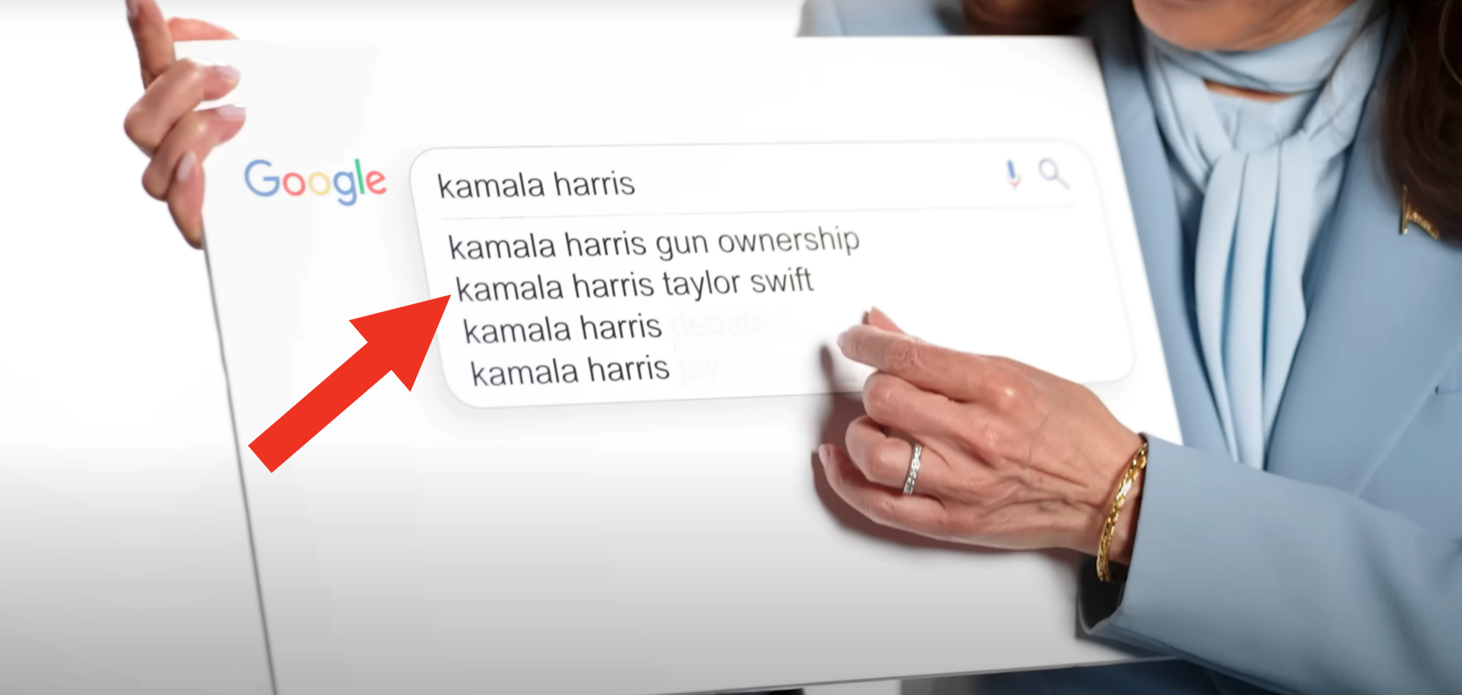 Close-up of a person pointing at a Google search for "Kamala Harris," showing search suggestions: "gun ownership," "Taylor Swift," and "Kamala Harris"