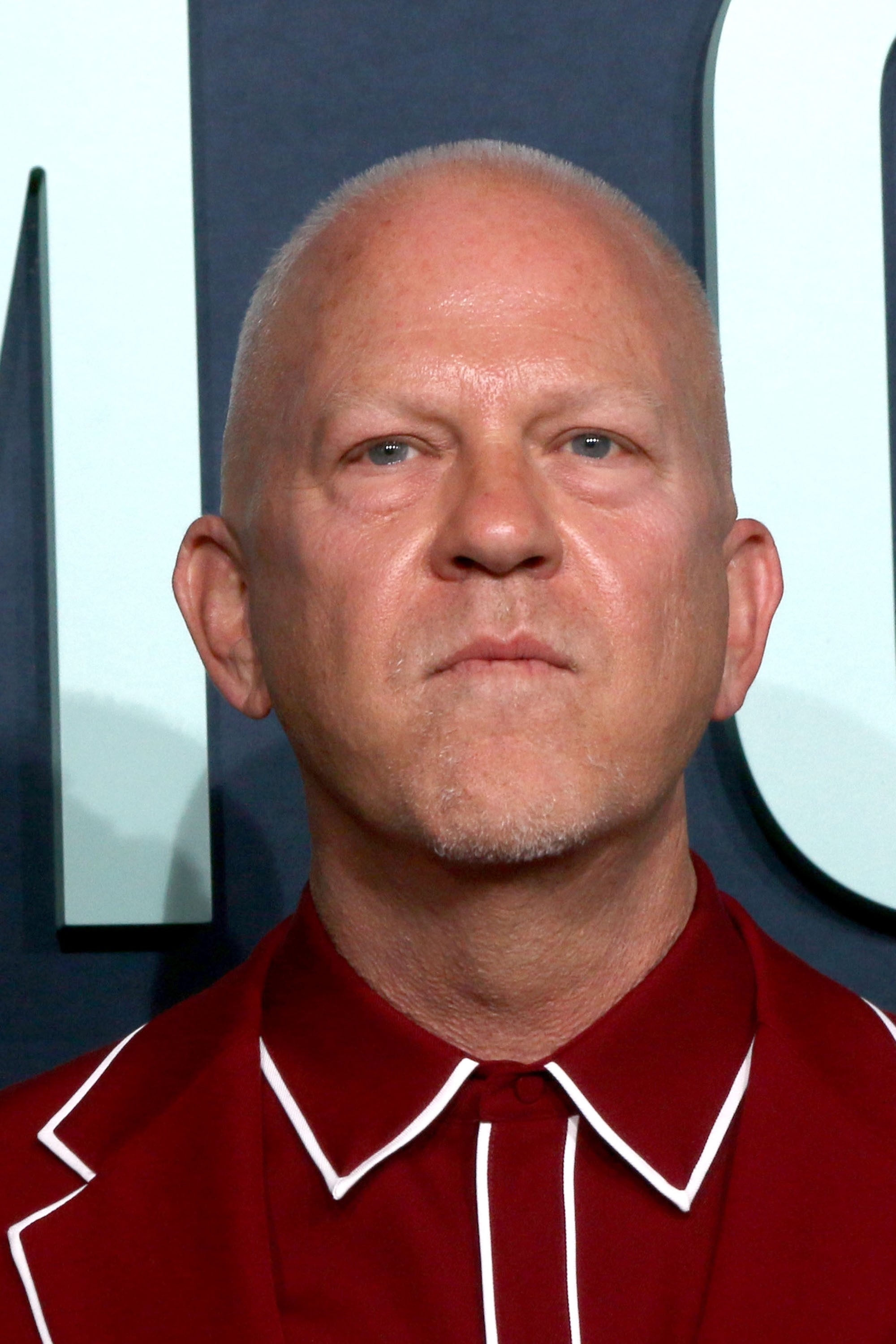 A person in a red carpet-style outfit looking directly at the camera