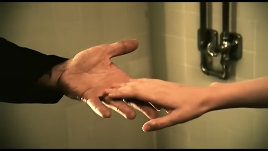 Two hands reaching for each other in a tender moment, suggesting intimacy and connection