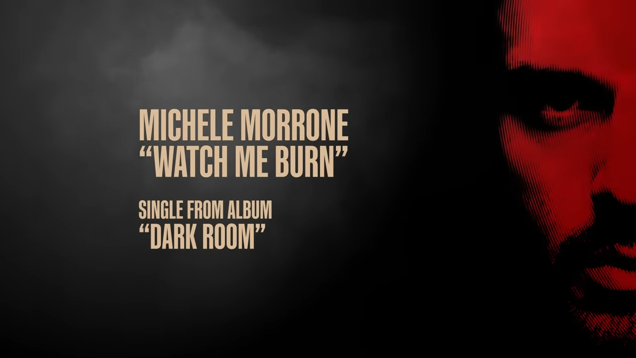 Michele Morrone's single "Watch Me Burn" from the album "Dark Room" is displayed in bold text with partial face art in the background