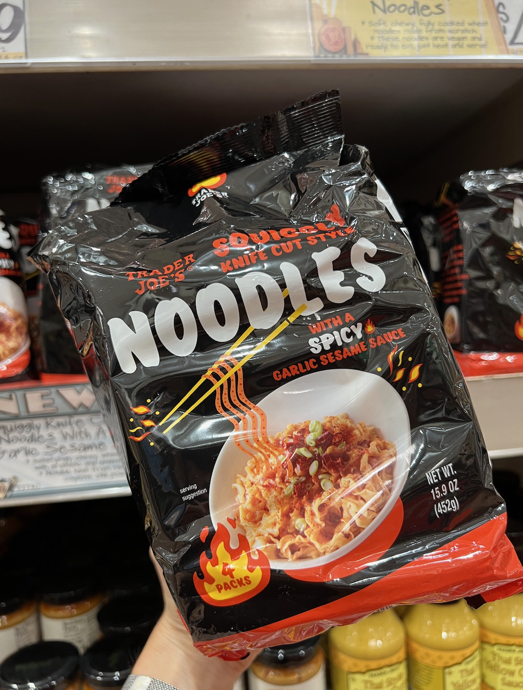 Close-up of a hand holding a package of Trader Joe's Soyaki Knife Cut Style Spicy Sesame Sauce Noodles