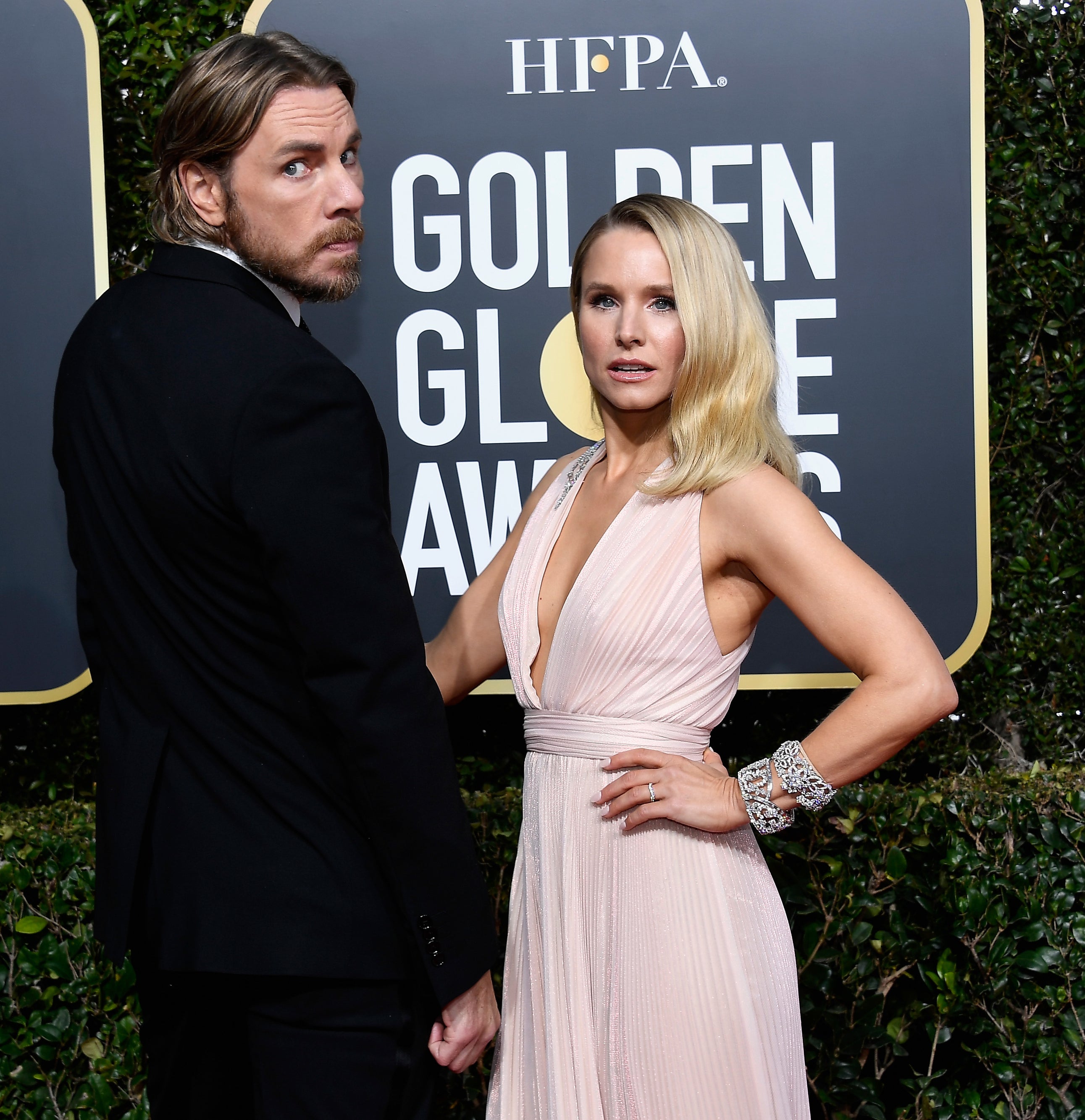 Dax Shepard and Kristen Bell on the red carpet at the Golden Globe Awards. Dax wears a black suit, and Kristen wears a flowing, sleeveless dress