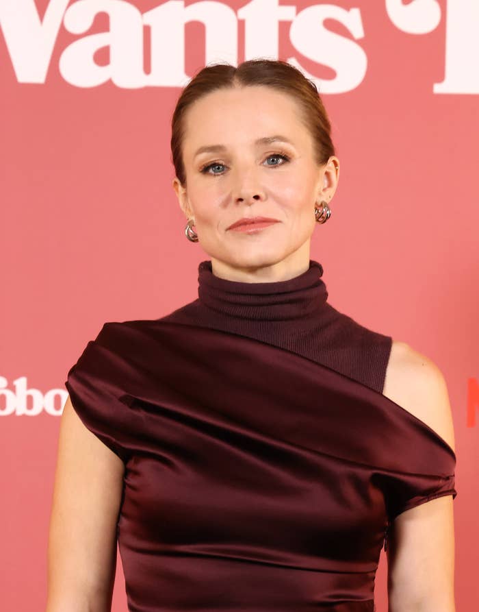 Kristen Bell attends a red carpet event in an elegant one-shouldered dress with a high collar