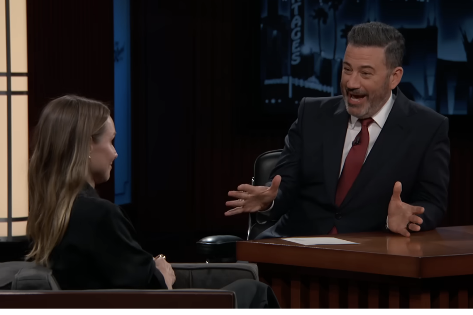 Kristen Bell and Jimmy Kimmel on "Jimmy Kimmel Live" talk show. Kristen is seated talking to Jimmy, who gestures animatedly. Text includes video title and YouTube details
