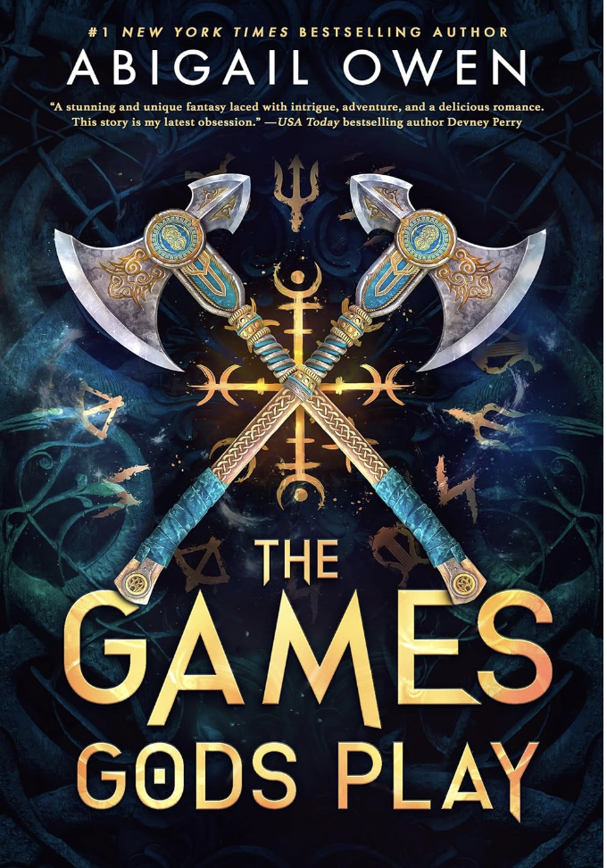 Book cover for "The Games Gods Play" by Abigail Owen, featuring crossed double-headed axes and mystical symbols against a dark background