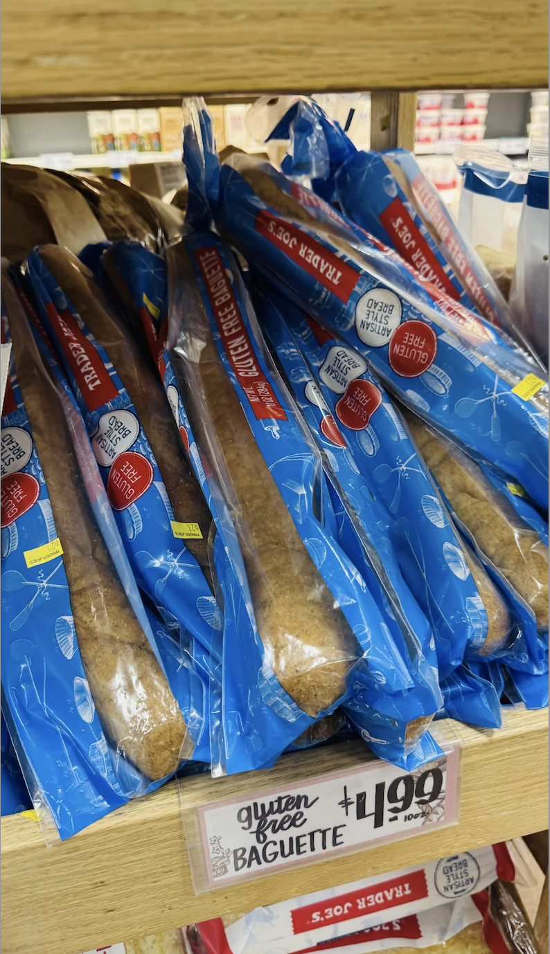 Gluten-free baguette packages stacked on a store shelf, with a price label reading $4.99