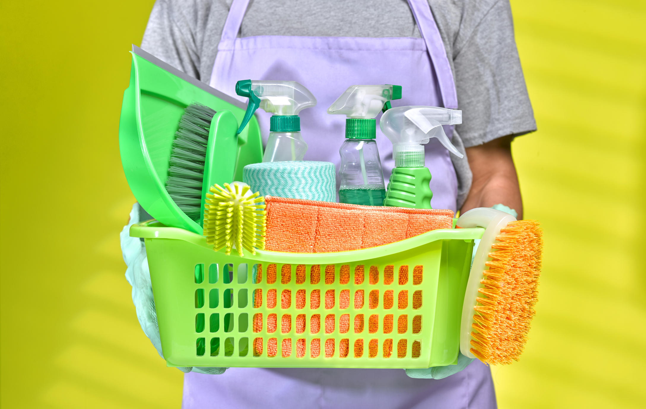 Person holding a basket filled with various cleaning supplies, including spray bottles, brushes, and cloths. The image is categorized as Internet Finds