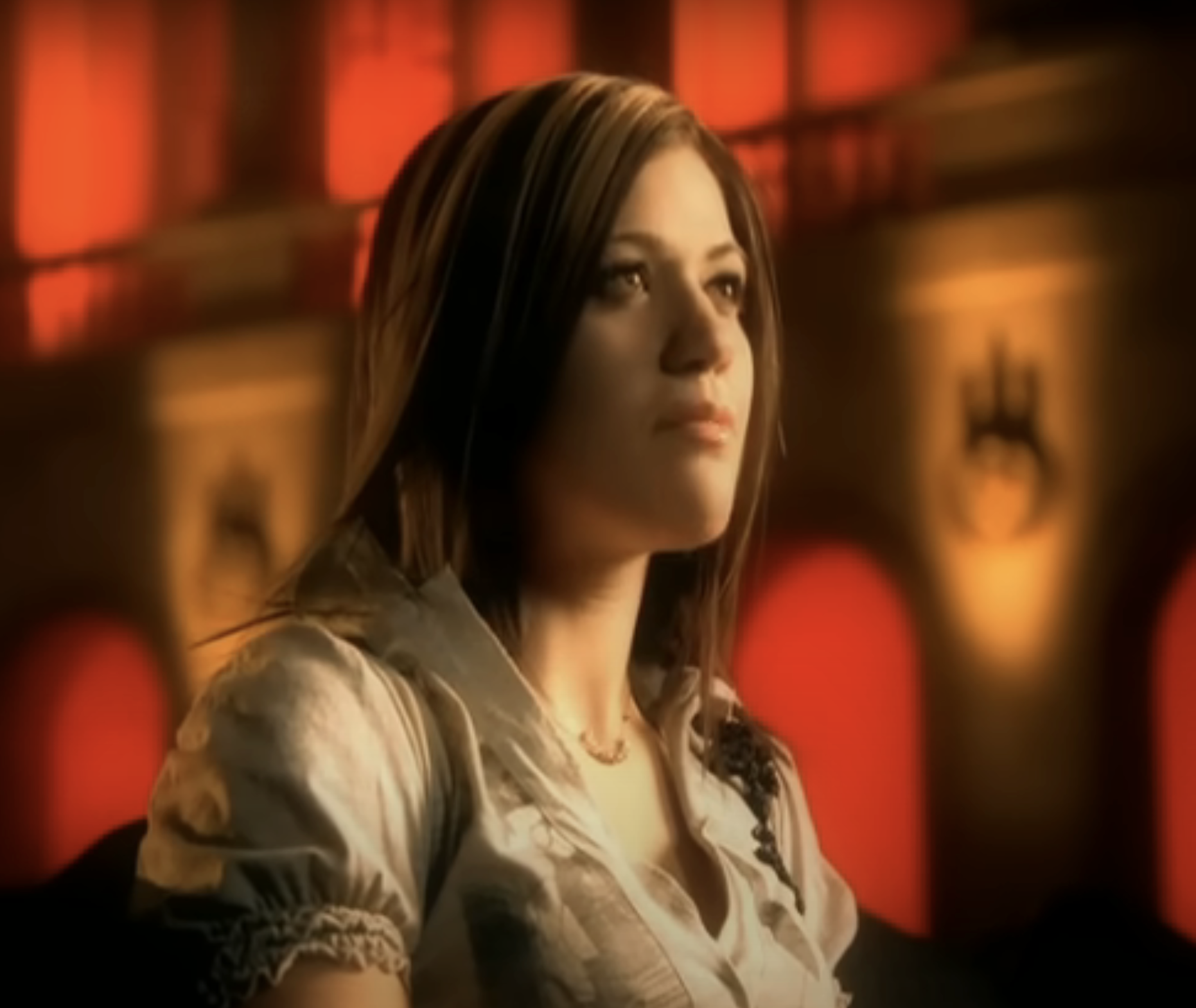 Kelly Clarkson in a scene from her "Because of You" music video, wearing a casual blouse
