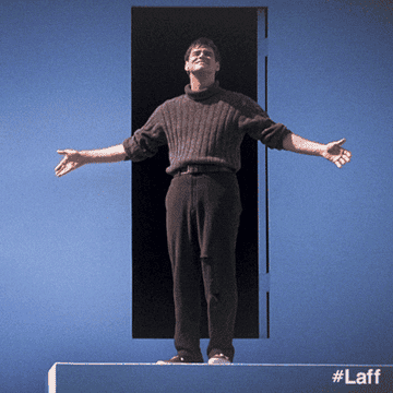 Jim Carrey stands with open arms emerging from a door, smiling. Text reads "#Laff" in the bottom right corner