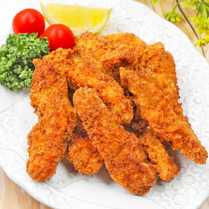 食べ物の画像。皿に盛られたフライドチキン、トマト、ブロッコリー、レモン。