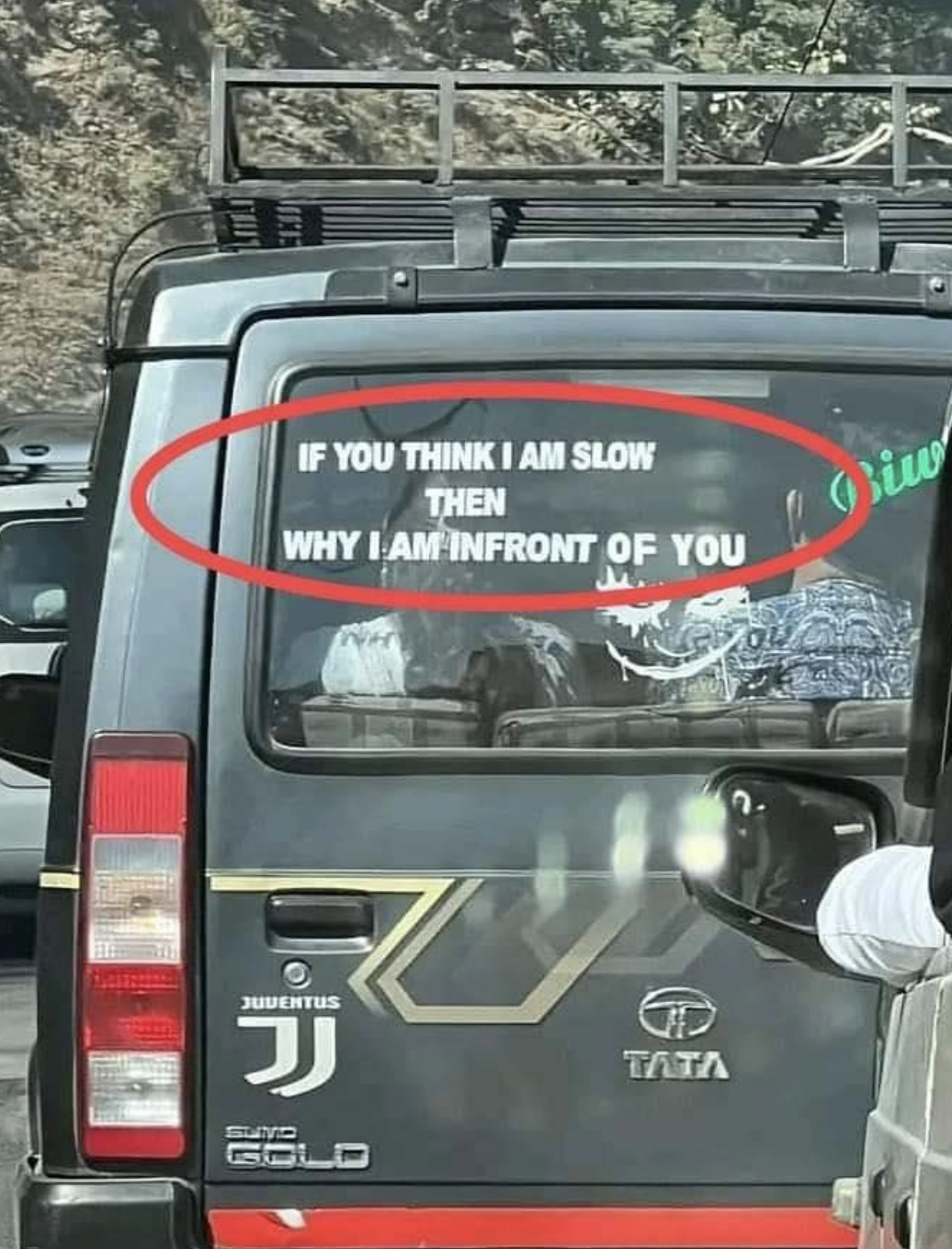 Rear of a van with a text sign: "IF YOU THINK I AM SLOW THEN WHY I AM INFRONT OF YOU"