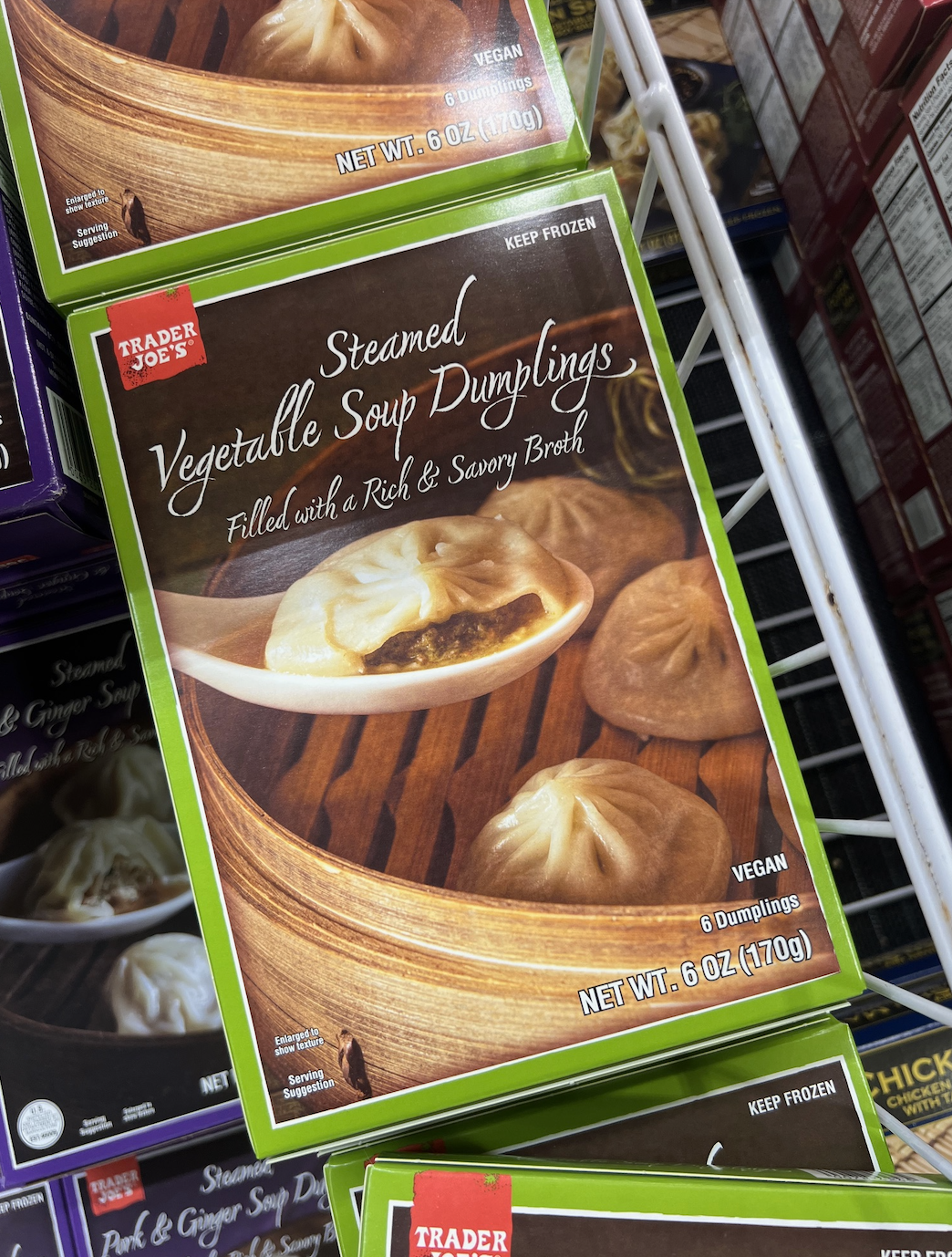 Box of Trader Joe's Steamed Vegetable Soup Dumplings, vegan, 6 count, filled with rich savory broth, 6 oz pack, displayed in a store freezer
