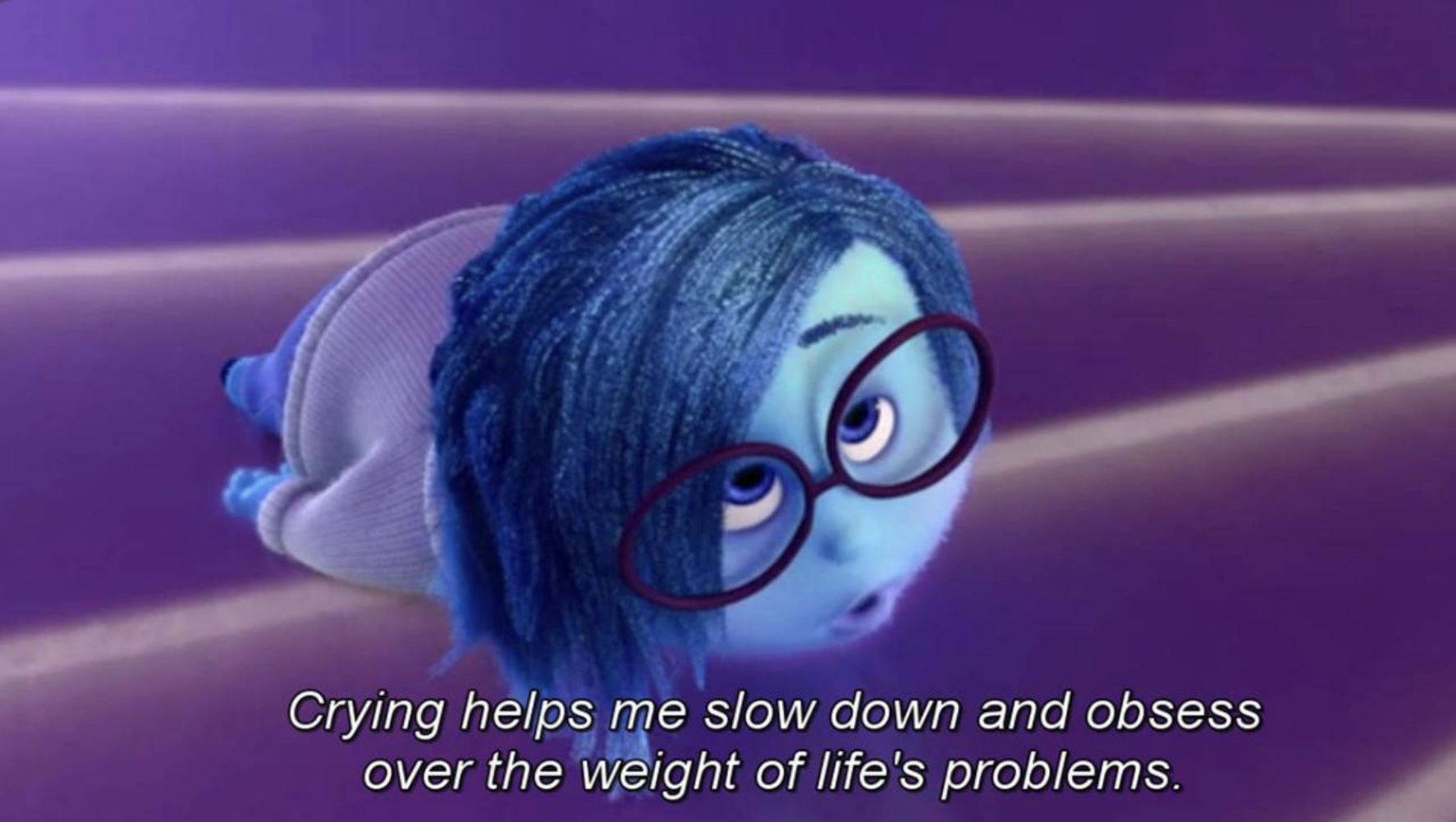 Sadness from Inside Out lying down and saying, "Crying helps me slow down and obsess over the weight of life's problems."