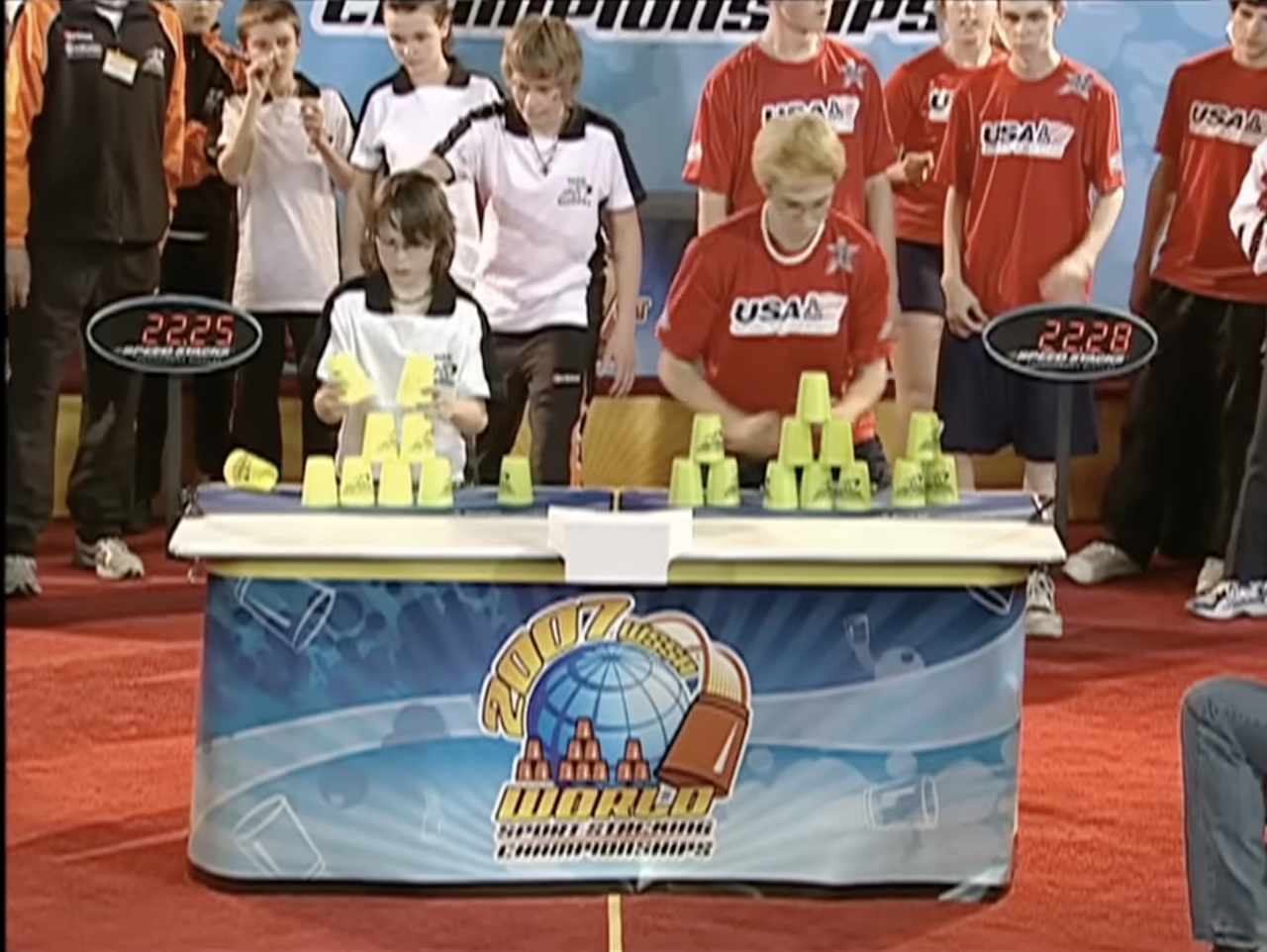 Connor Strutt and Emily Fox in a 2007 World Sport Stacking Championships match, each focused on stacking cups as onlookers and competitors watch