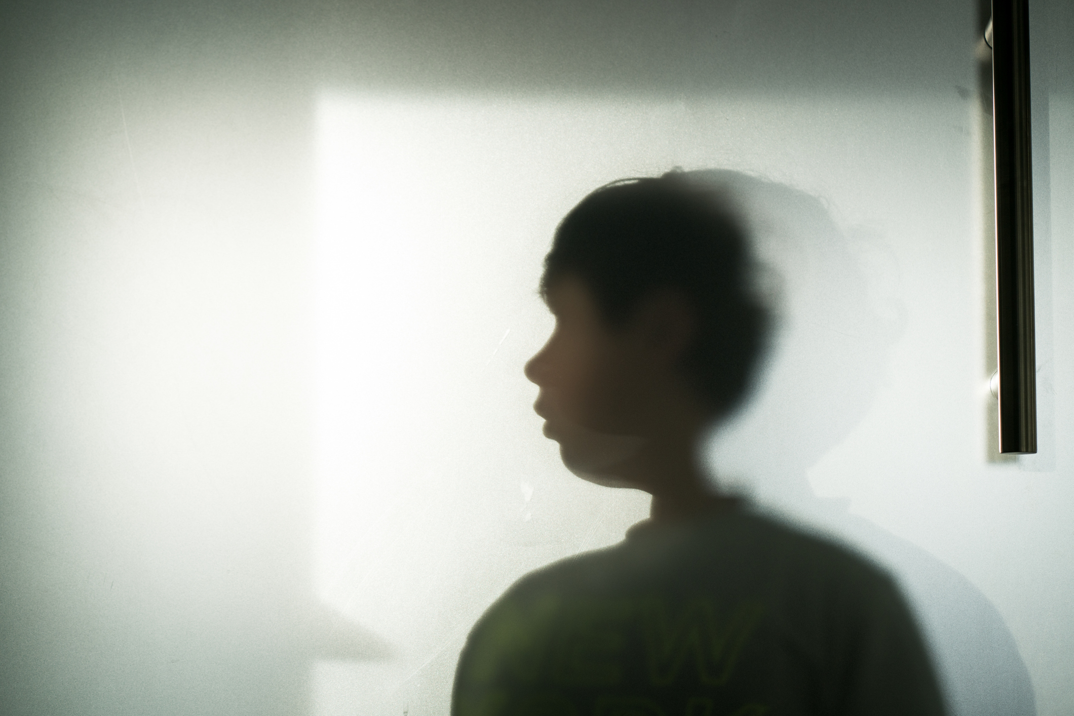 A silhouette of a young child is shown against an illuminated background, creating a mysterious atmosphere