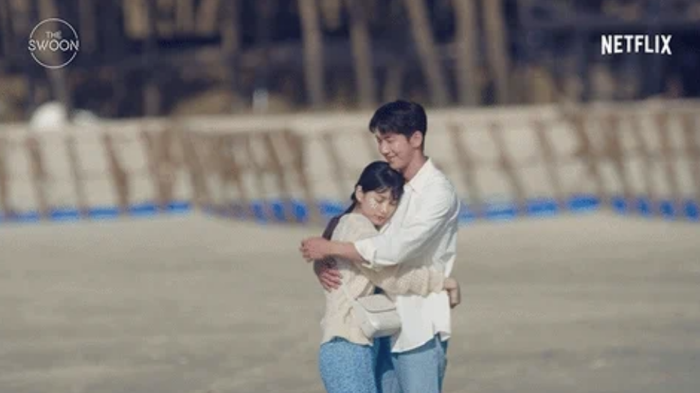 Suzy Bae and Nam Joo-hyuk embrace on a beach, scene from Netflix's "The Swoon."