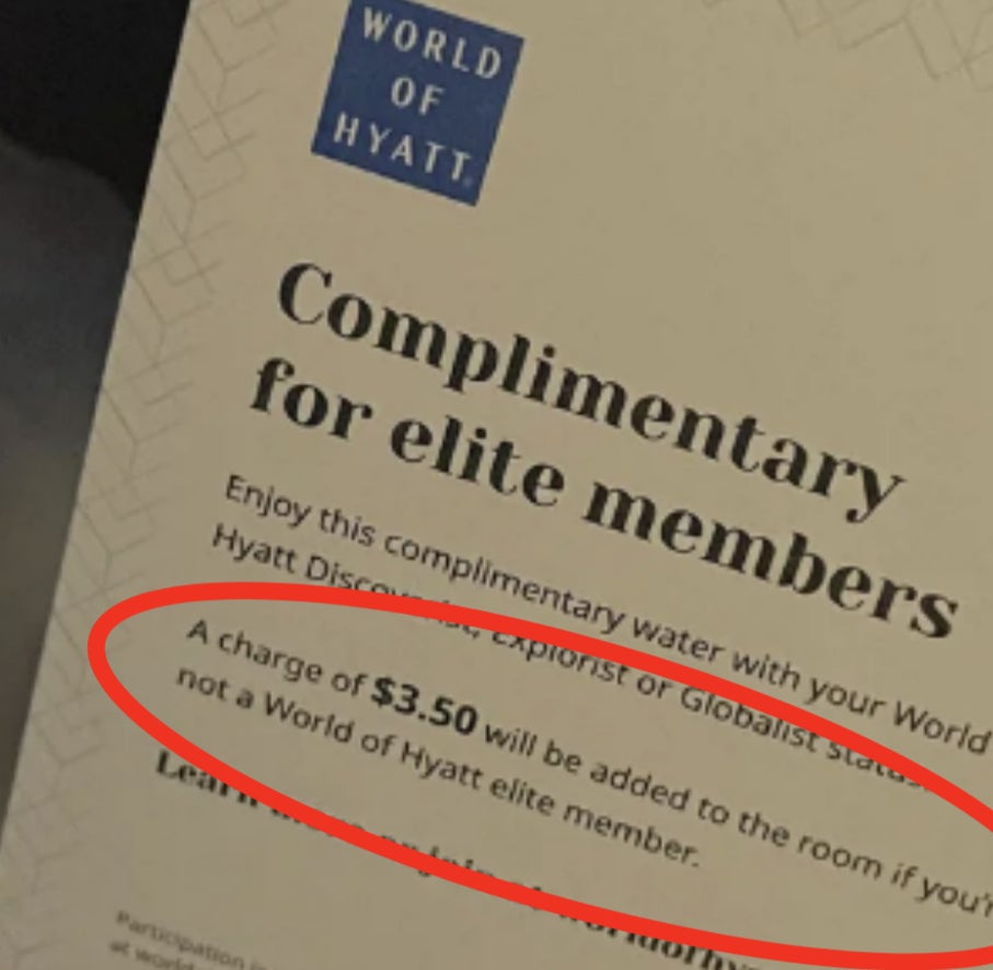 A water bottle with a tag that reads, "Complimentary for elite members. A charge of $5.50 will be added to the room if you're not a World of Hyatt elite member."