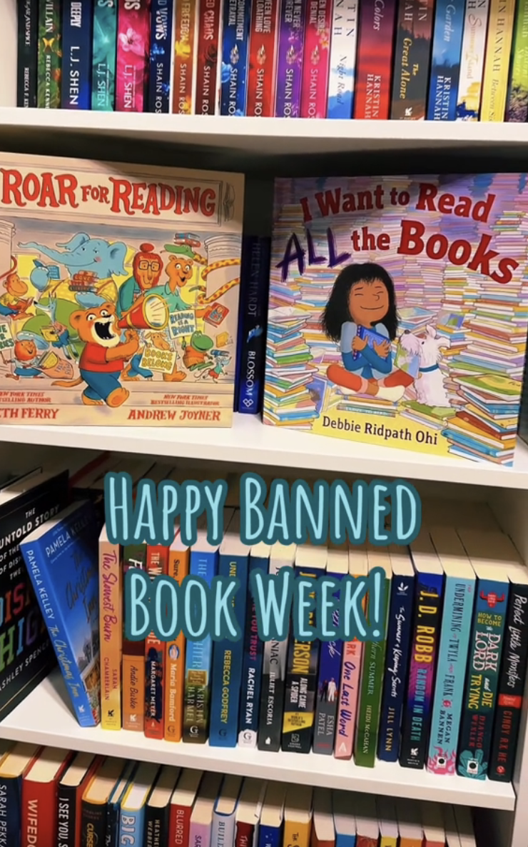 Two children's books, "Roar for Reading" by Michael Ferry and Andrew Joyner, and "I Want to Read ALL the Books" by Debbie Ridpath Ohi, with text "Happy Banned Book Week!" in front