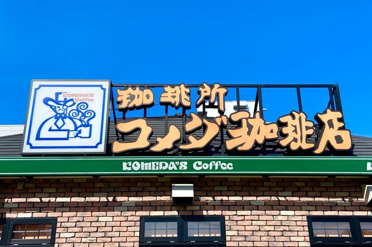 レンガ造りの建物上に「珈琲所コメダ珈琲店」と書かれた看板と「KOMEDA's Coffee」の英文字が表示されています。