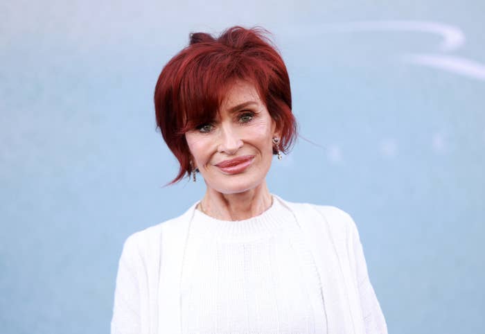Sharon Osbourne is wearing a sweater, posing for a photo with a smile