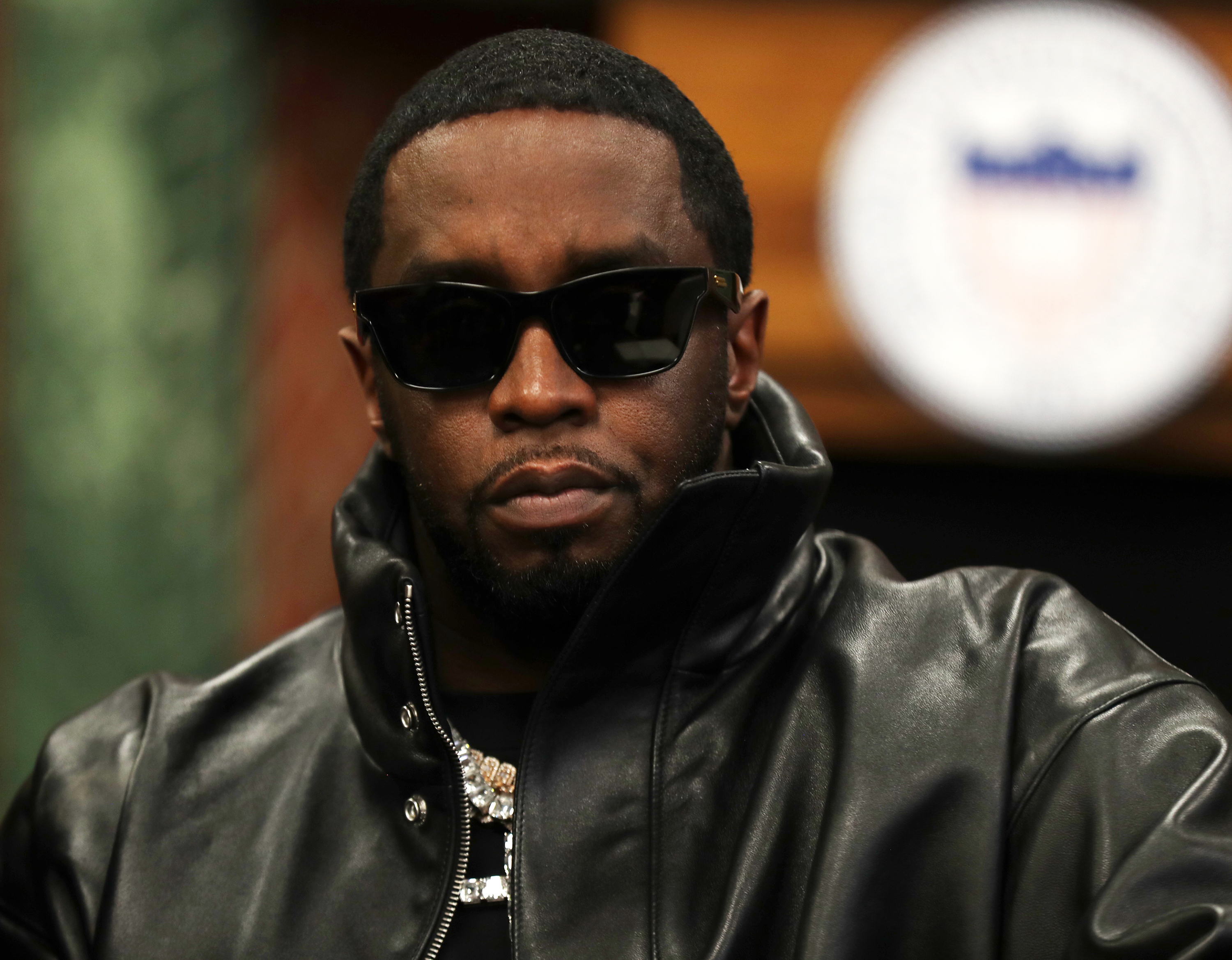 Sean "Diddy" Combs wears sunglasses and a leather jacket at an event