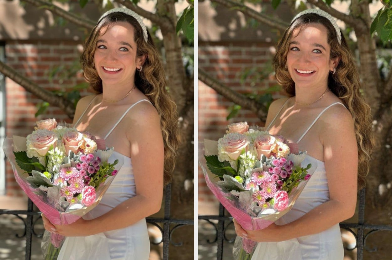 Bride smiling and holding a bouquet of roses and carnations outdoors