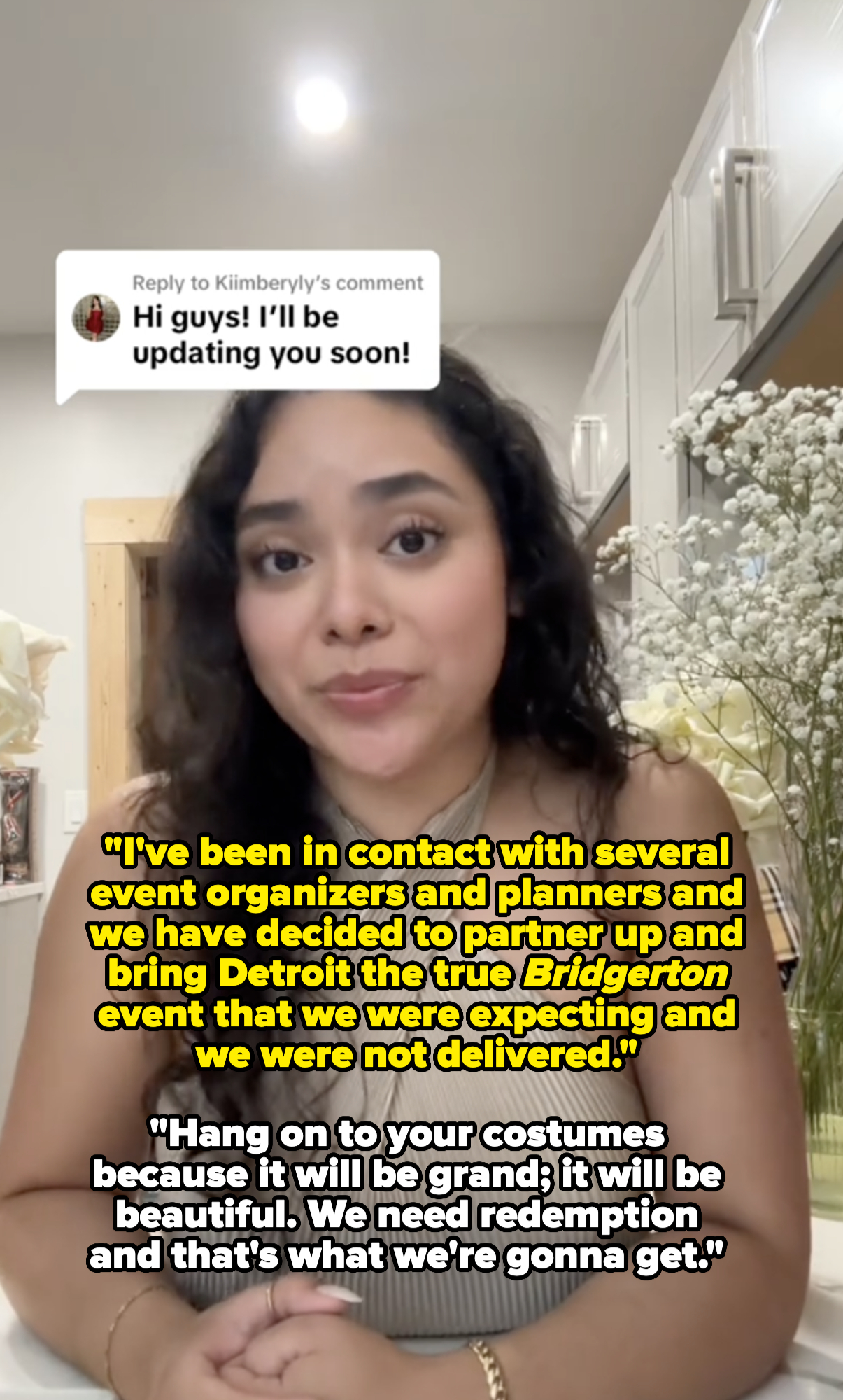 Kimberly Loaiza in a kitchen, wearing a sleeveless, halter-neck top, responds to a comment saying "Hi guys! I'll be updating you soon!"