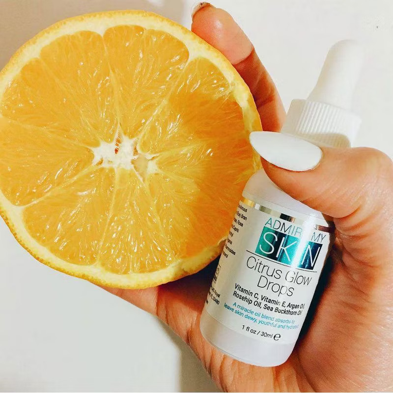 Model holding the glow drops and an orange sliced in half