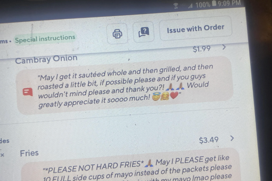 Close-up of a phone screen displaying a food delivery order: The order includes fries with special instructions for soft fries, extra silverware, a stack of napkins, and more mayo