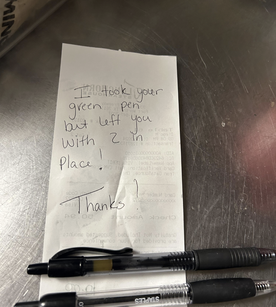 Note with handwritten message: "I took your green pen but left you with 2 in place, Thanks!" Two black pens are placed on the note