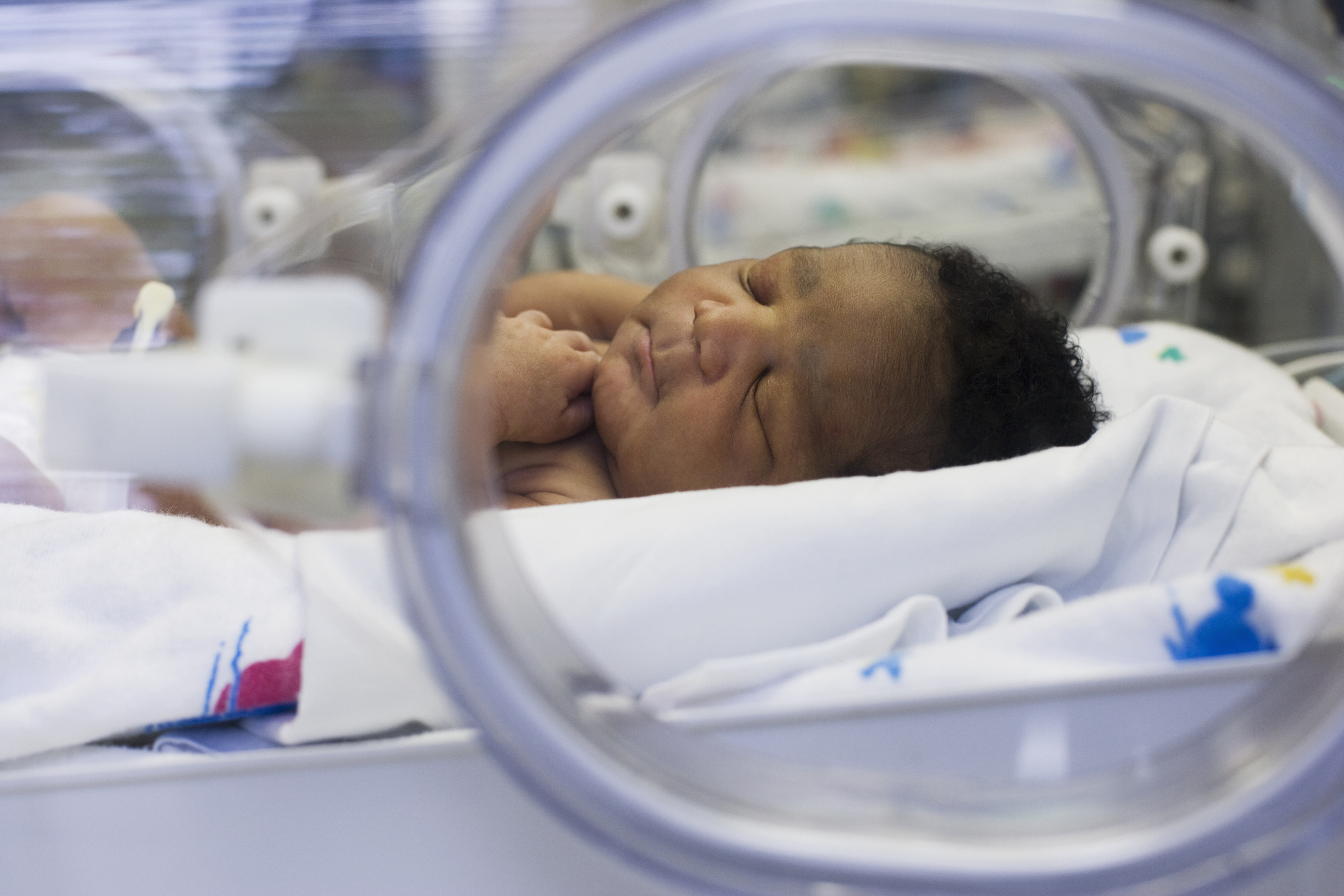 Newborn baby sleeping in an incubator at a hospital NICU