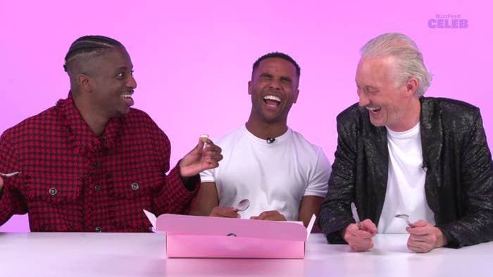 From left to right, Samuel Arnold, Lucien Laviscount, and Bruno Gouery share a laugh while eating from a pink box on BuzzFeed Celeb