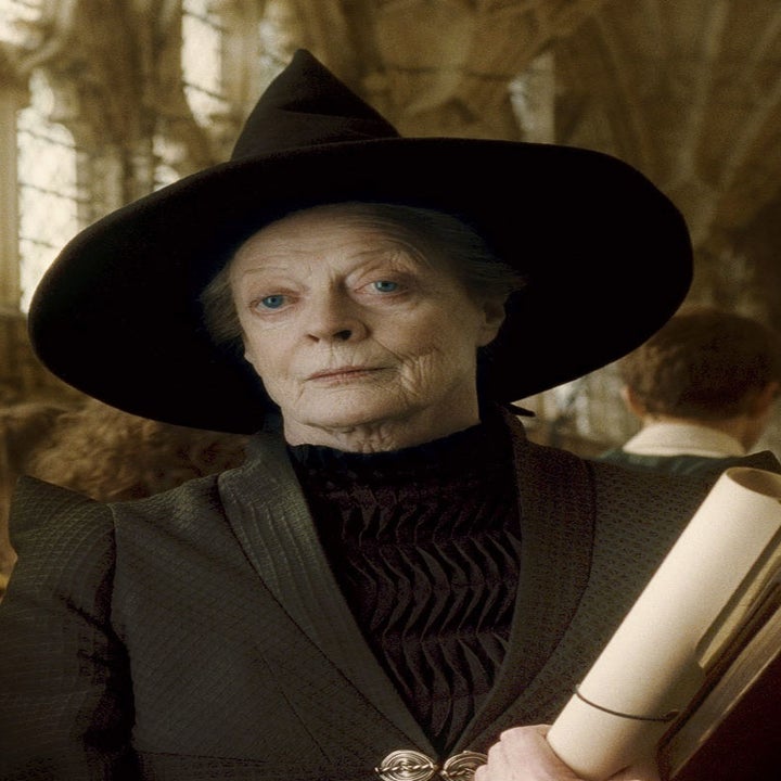 Maggie Smith as Professor McGonagall, wearing a witch's hat and holding scrolls, stands in a hall filled with people in the Harry Potter film series