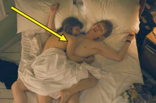 Daniel Radcliffe and a woman lie in bed covered by a white sheet