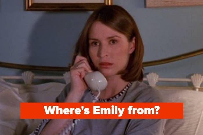 Woman with short brown hair holding a phone in TV scene. Text overlaid reads: "Where's Emily from?"