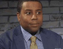 Kenan Thompson on Saturday Night Live, wearing a suit and tie, looking to the side with a nuanced expression