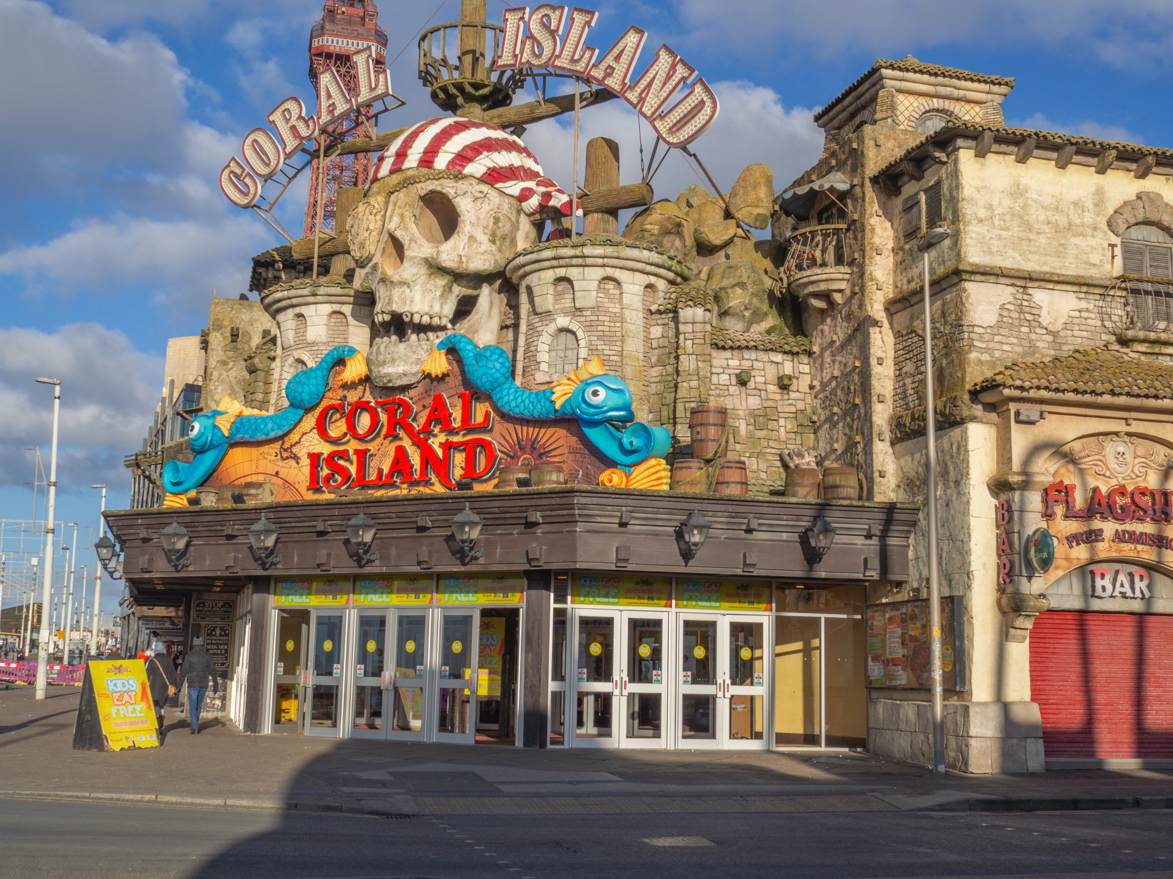 The exterior of the Coral Island arcade in Blackpool, features a pirate-themed facade with a skull, ship elements, and colorful aquatic decorations