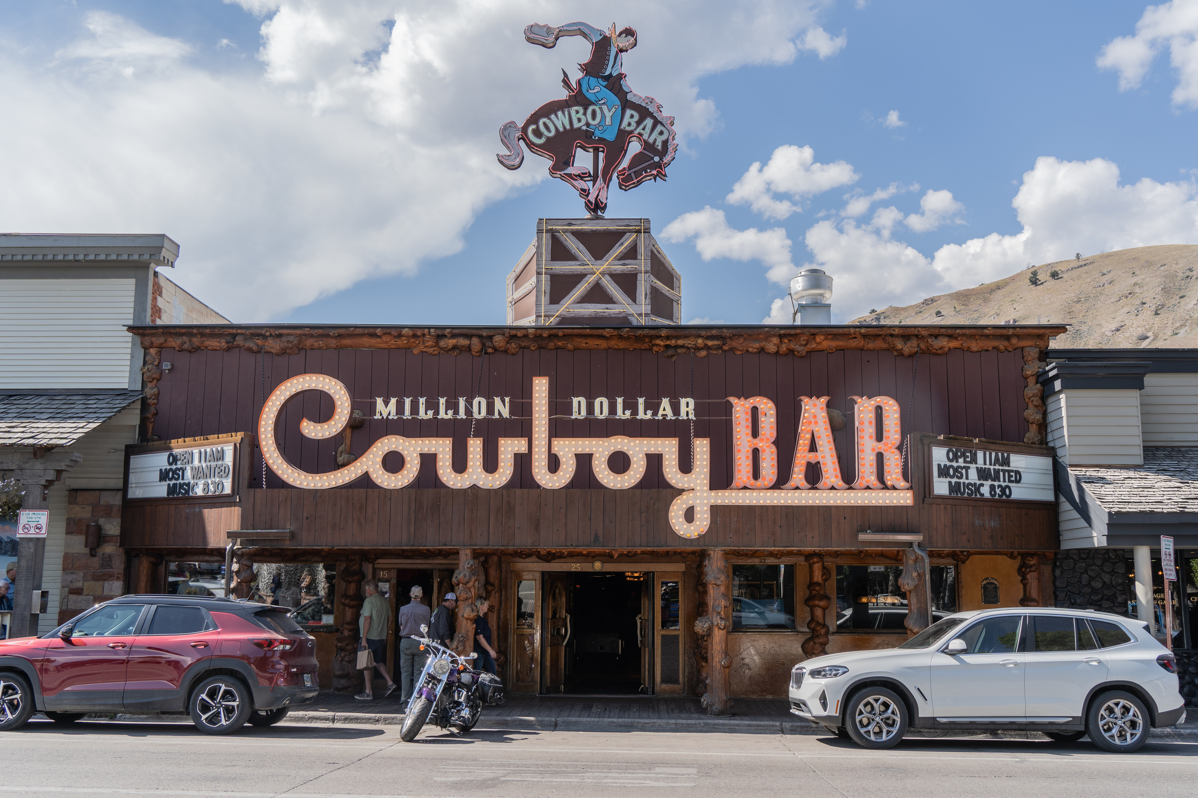 People stand outside the Million Dollar Cowboy Bar in Jackson Hole, Wyoming, which has a cowboy statue on the roof