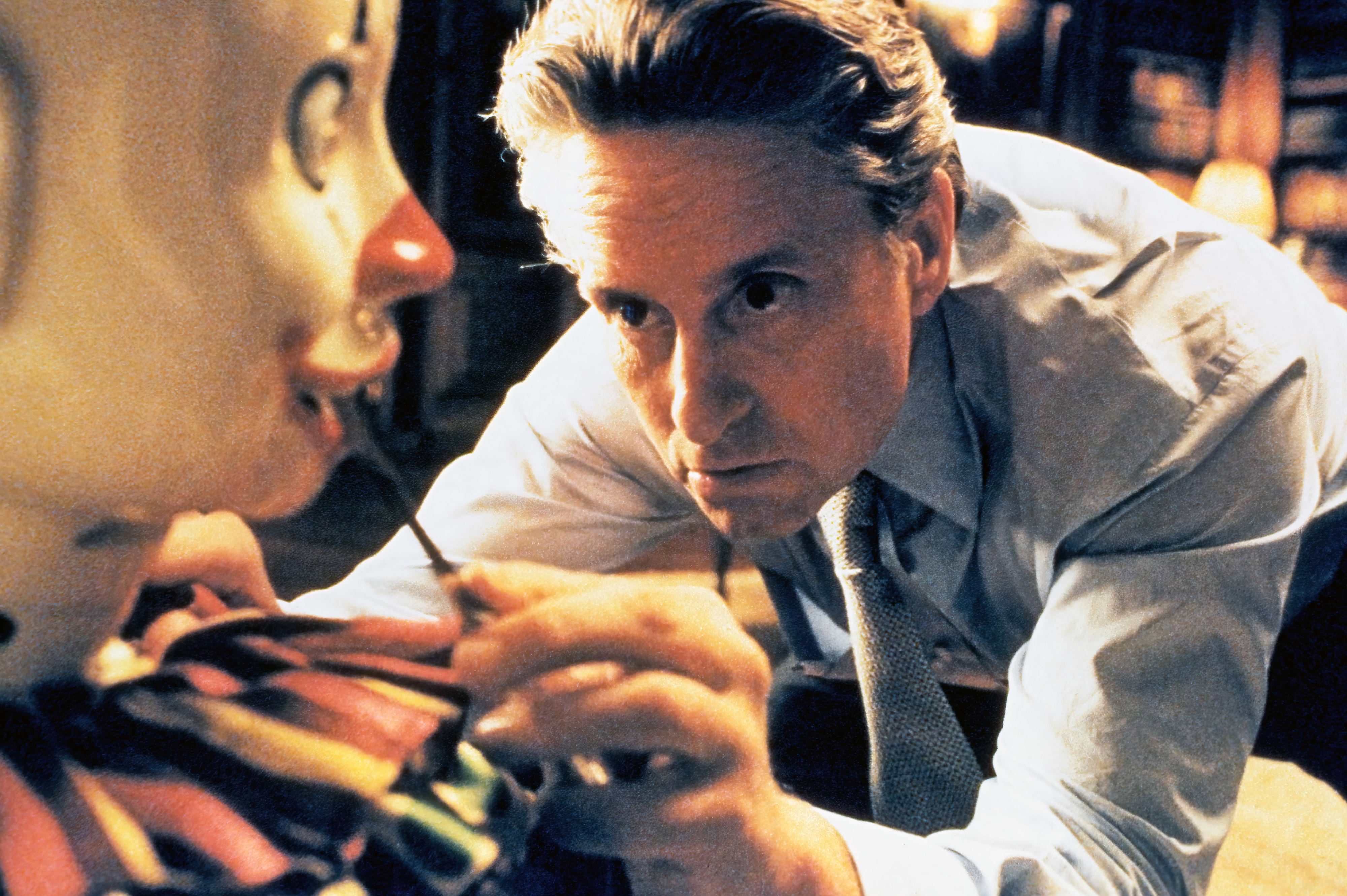 Michael Douglas intensely examines a toy clown in a dramatic movie scene
