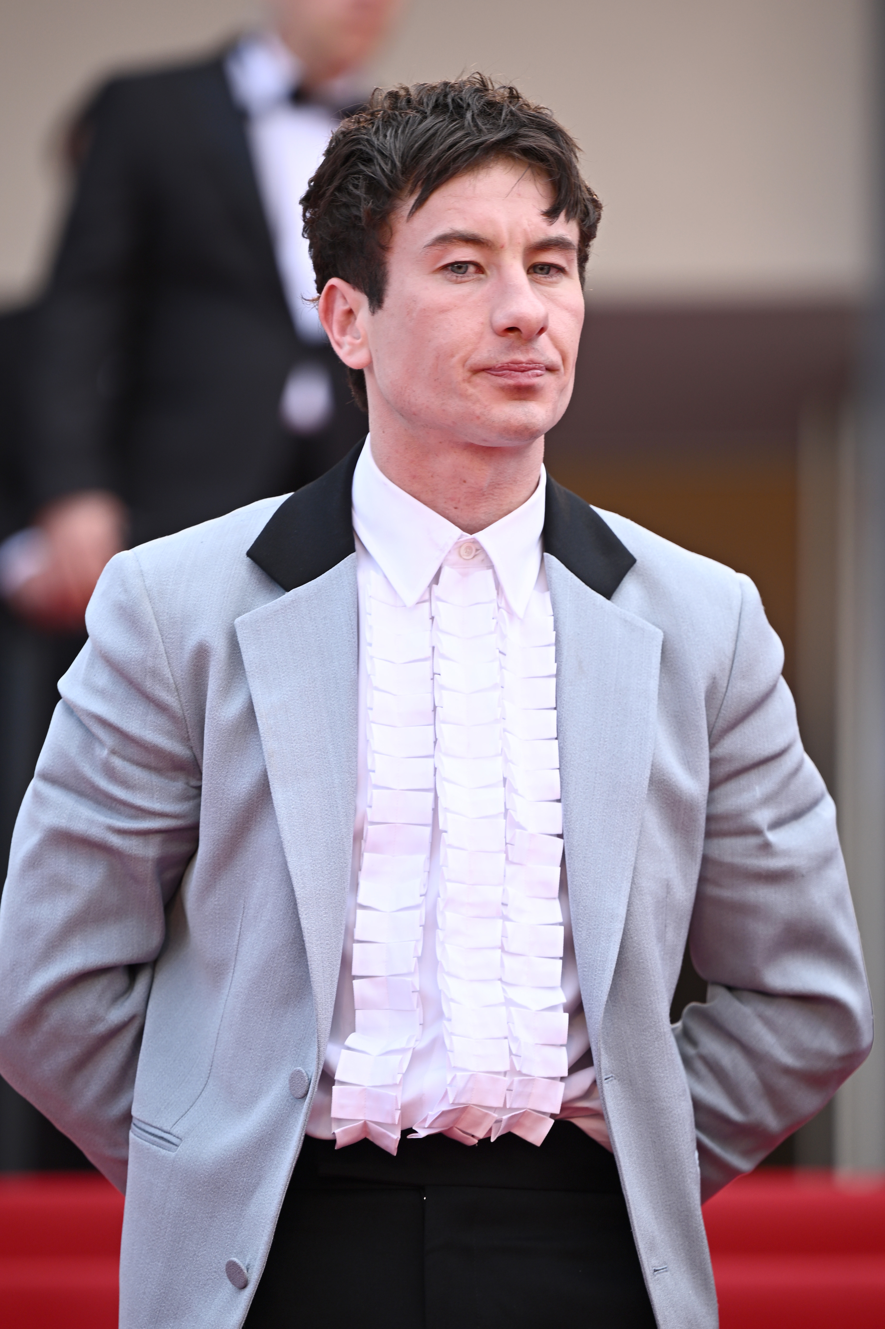Barry Keoghan on the red carpet in an evening suit with a ruffled white shirt and light-colored jacket