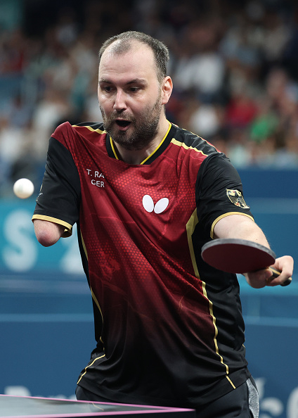 Para table tennis player Thomas Rau in action during a match, wearing a sports jersey