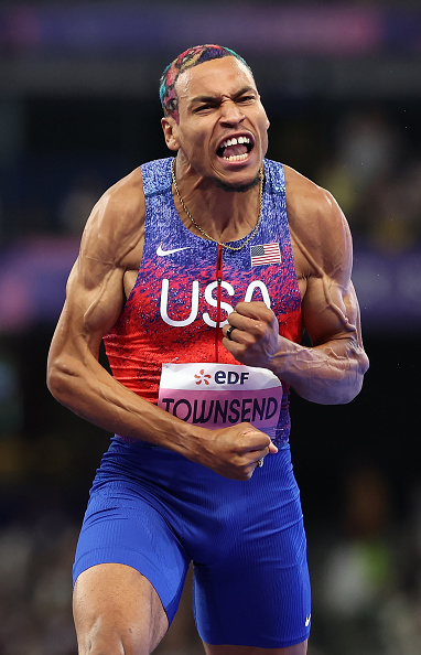 David Townsend, wearing a USA track uniform, celebrates energetically during a track event. The name "Townsend" is visible on his uniform