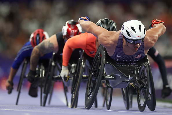 Paralympic athletes compete in a wheelchair race, displaying strength and determination