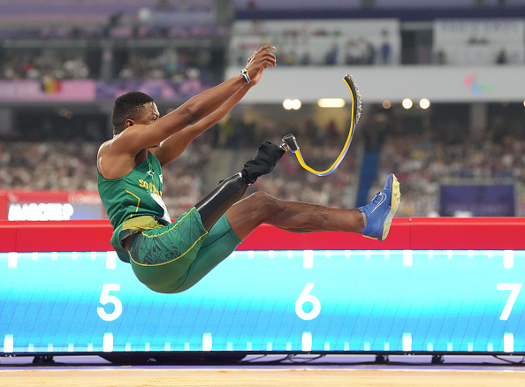 Track and field athlete jumping with prosthetic leg during a long jump event