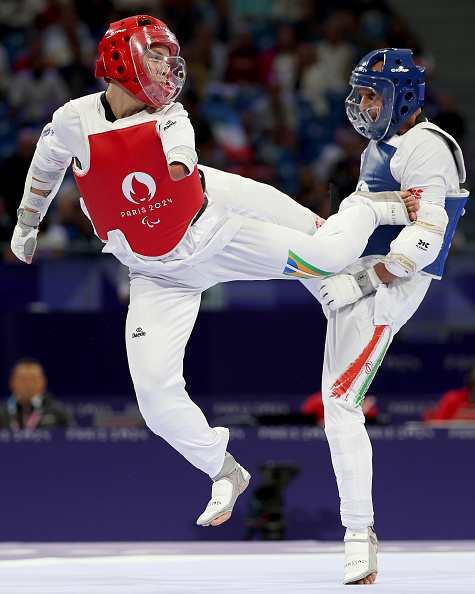 Para Taekwondo match at the Paris 2024 Paralympic Games. Two athletes in protective gear, one delivering a kick to the other