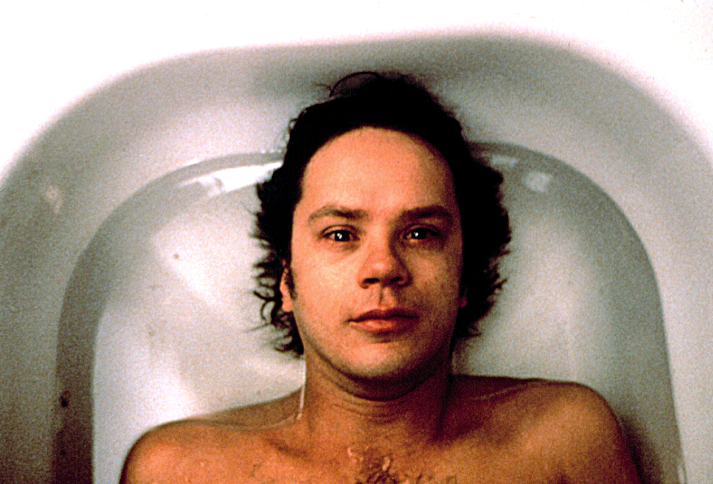 Tim Robbins lies in a bathtub with a neutral expression, from the movie &quot;Jacob's Ladder.&quot;