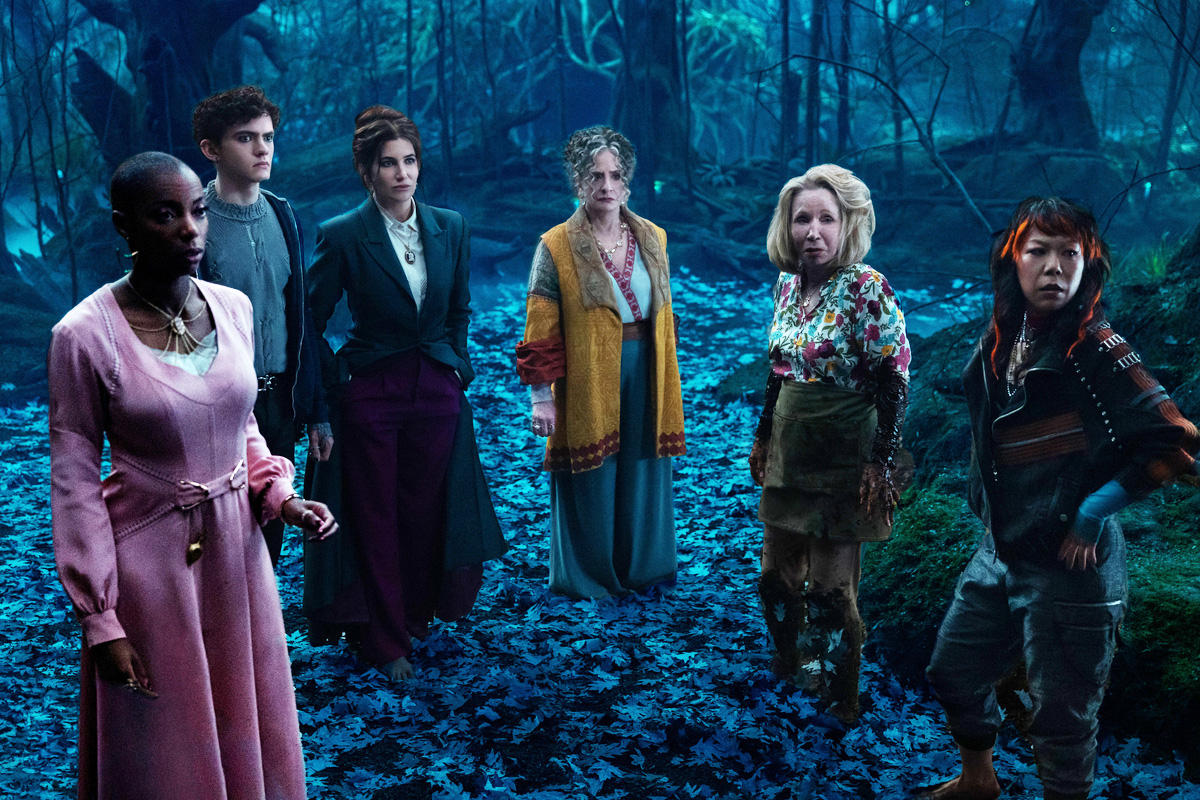 Kathryn Hahn, Joe Locke, Patti LuPone, and more standing in the woods in a scene from "Agatha All Along"